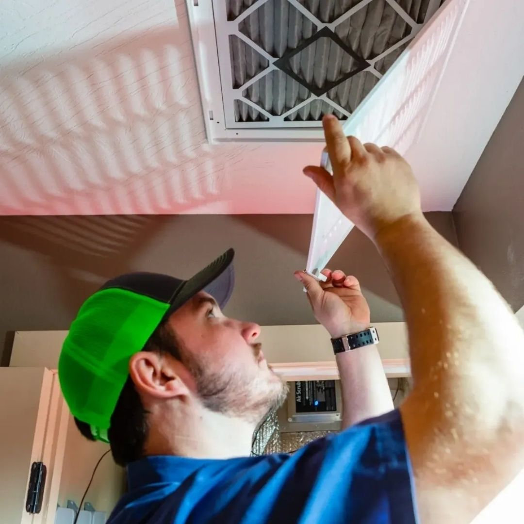 Redeemed HVAC technician replacing a ceiling return air filter in a Nixa, Missouri home