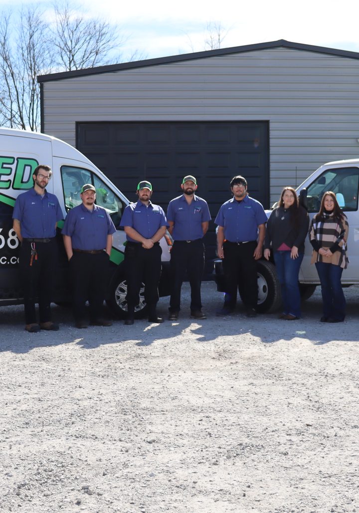 The Redeemed HVAC & Plumbing team outside their shop with the company service vehicles, ready for 24/7 emergency calls